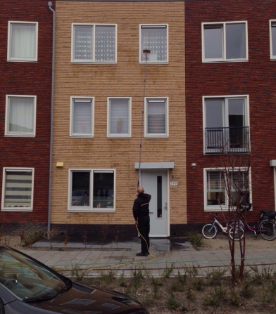 Glazenwasser maakt ramen schoon met telescoop